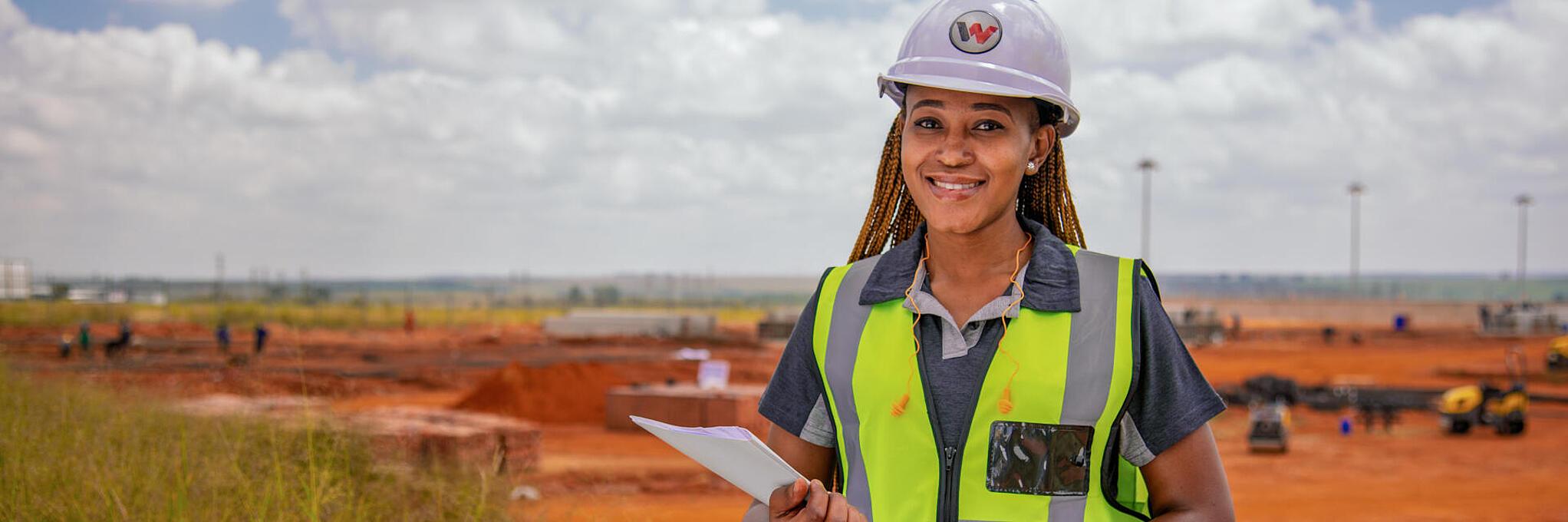 smiling colleague in front of construction site