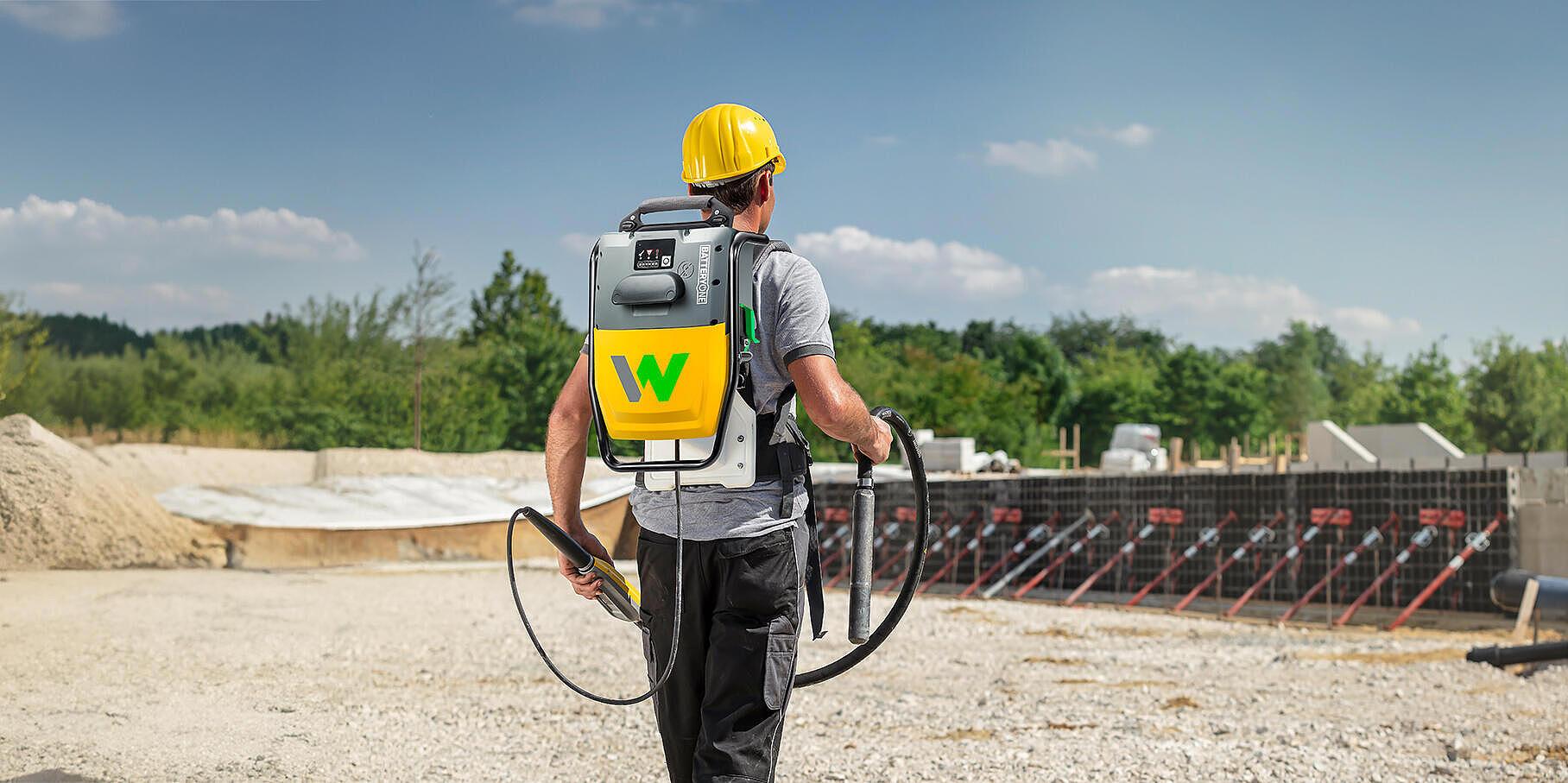 worker with an internal vibrator backback on a construction site
